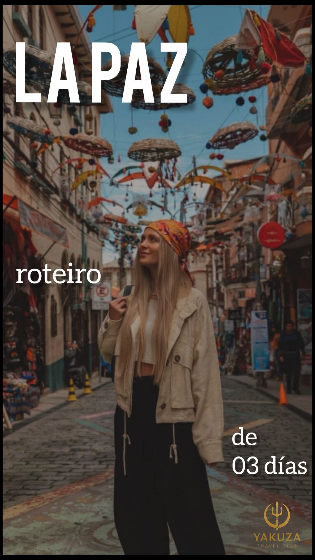 Blonde woman looking up on a La Paz street with colorful hanging baskets and umbrellas.